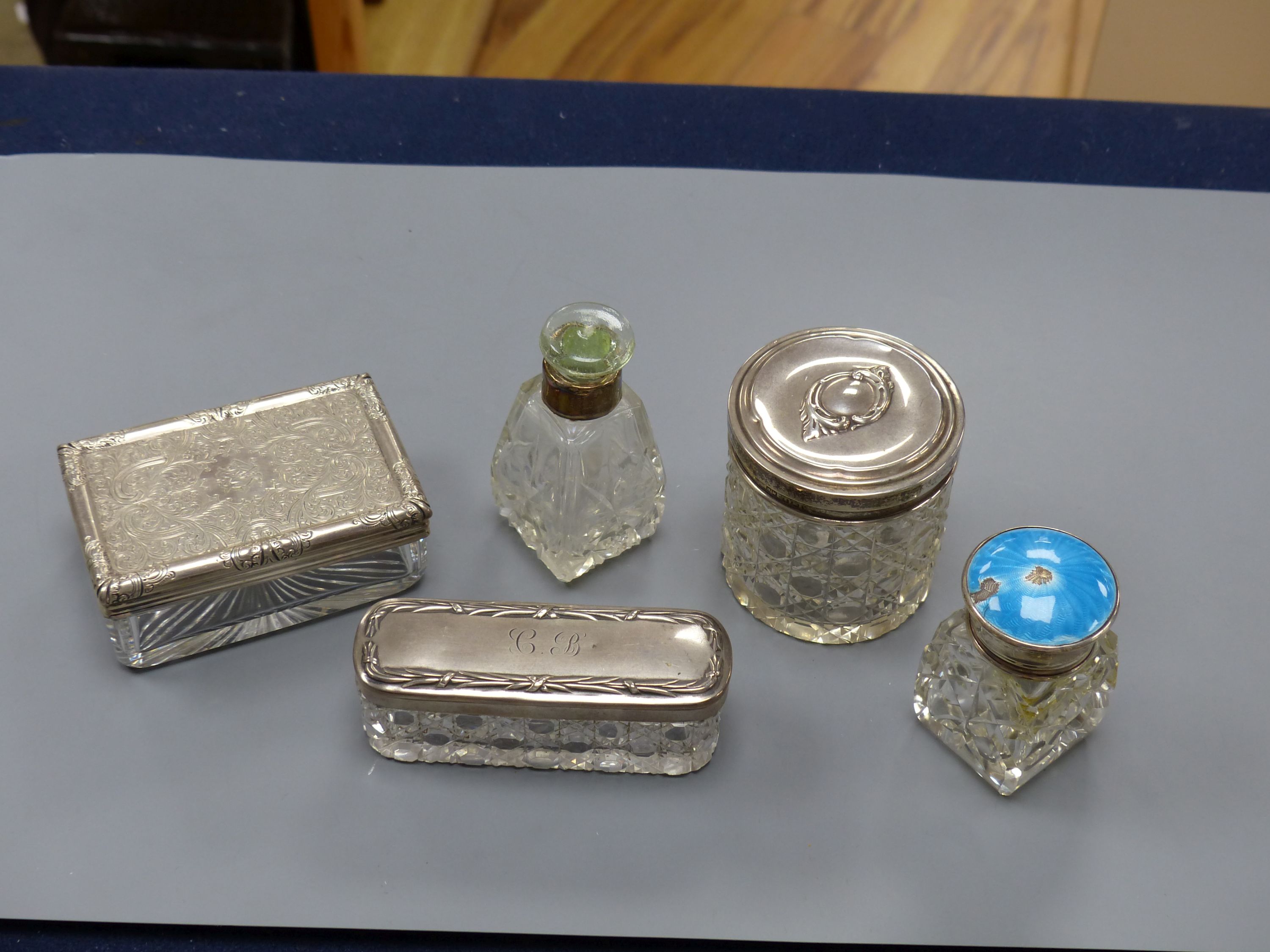 A Victorian silver mounted glass toilet jar, 98mm, four other silver mounted toilet jars, including one with enamel(a.f.).